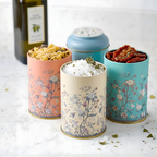 MARIA ROMA Botanica small floral spice jars used for storing sea salt, pasta, and sun-dried tomatoes on a bright marble countertop.